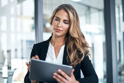 professional women sitting in office holding tablet